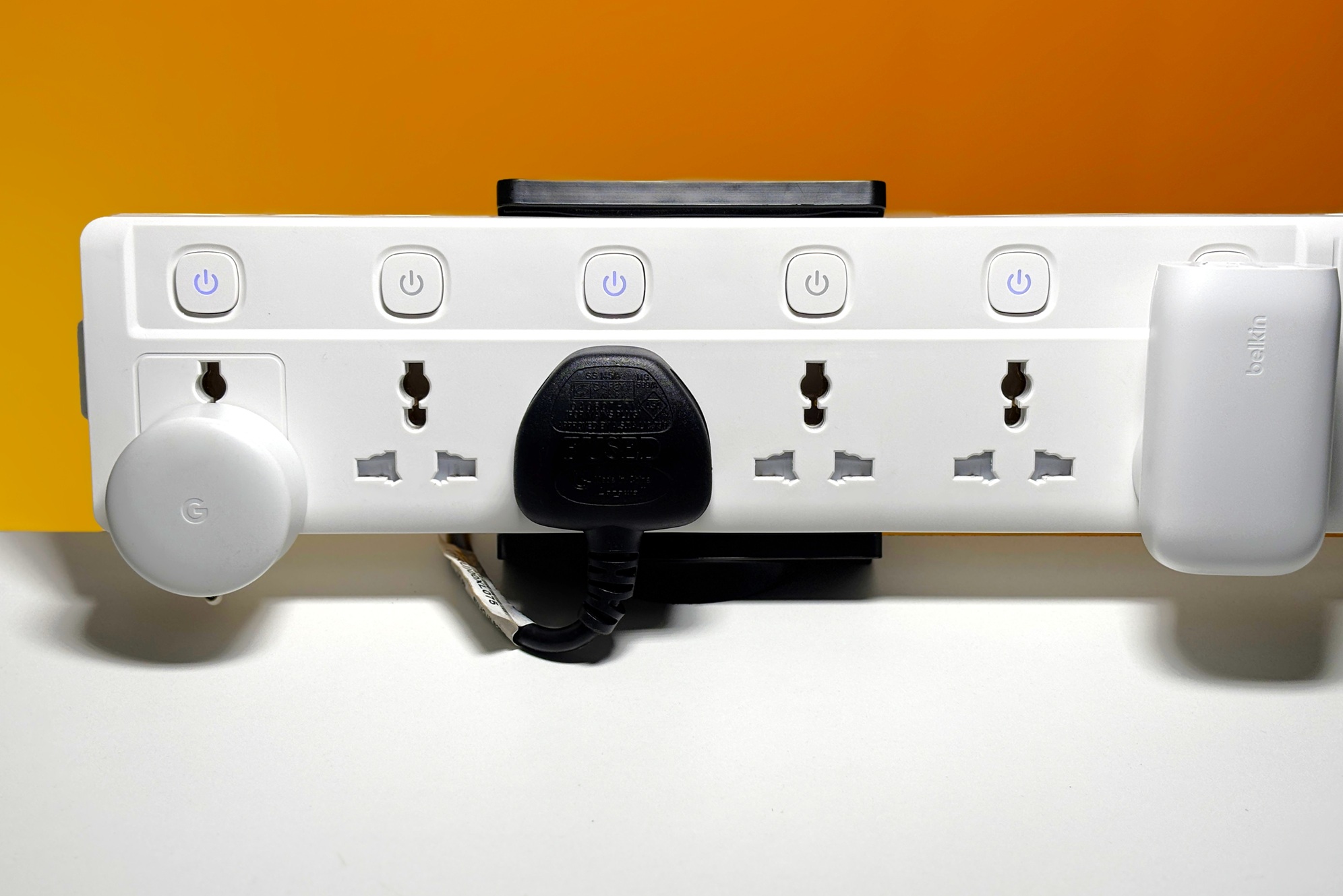 Power strip holder holding a power strip with a few sockets in use